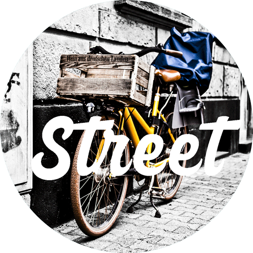 button-street-fotografie-fahrrad-welches-an-die-hauswand-gelehnt-ist-und-das-wort-street