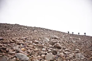vier-bergsteiger-gehen-on-der-entfernung-ein-geroellfeld-hinauf