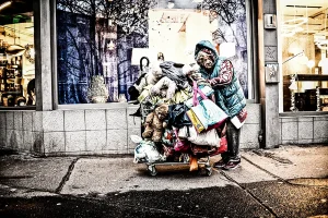 eine-obdachlose-mit-einkaufswagen-voller-stofftiere-schaut-direkt-in-die-kamera