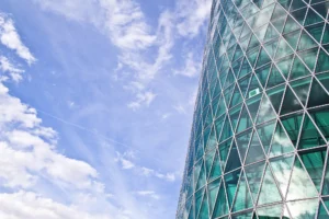 aussenfassade-aus-glas-westhafentower-frankfurt-mit-blauem-himmel